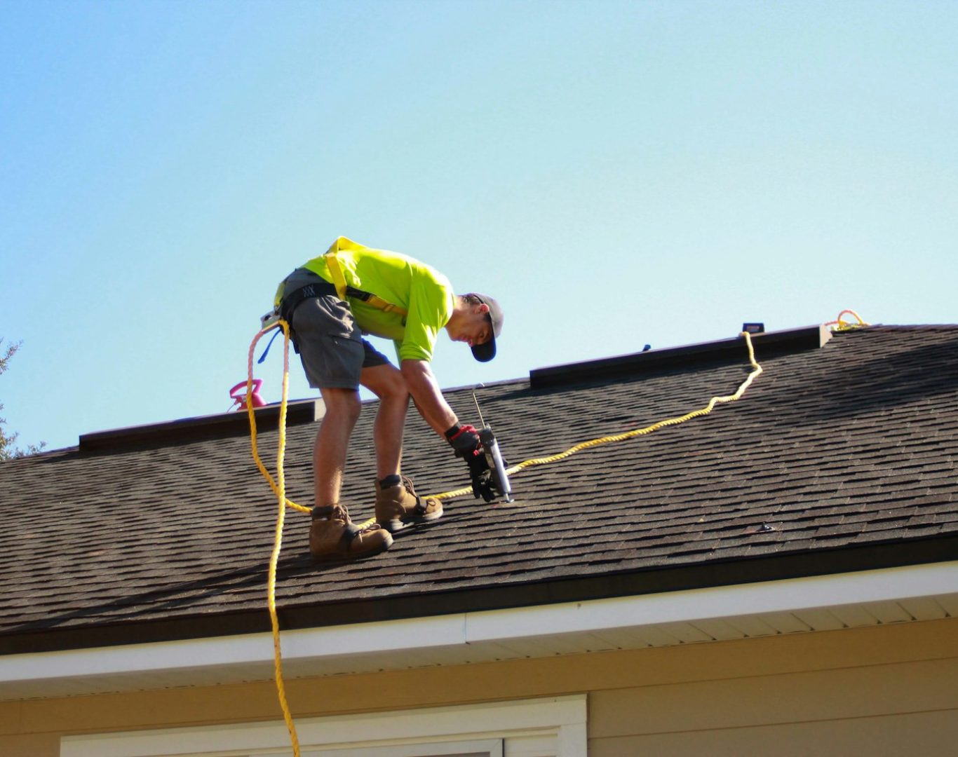 a man working on a roof with a power drill